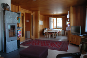 Wohnzimmer mit Ofen und Esstisch